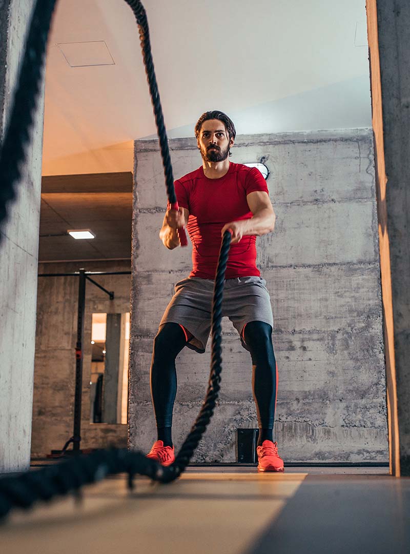 image of a young man performing battle ropes exercise